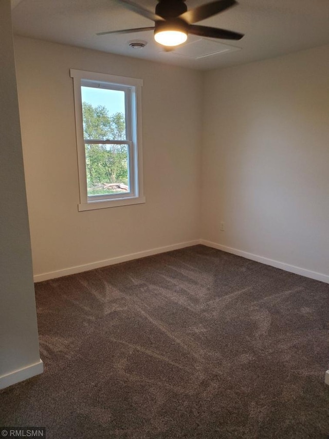 unfurnished room featuring ceiling fan and dark carpet