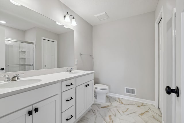 bathroom featuring an enclosed shower, vanity, toilet, and a textured ceiling