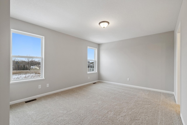 carpeted spare room with a textured ceiling