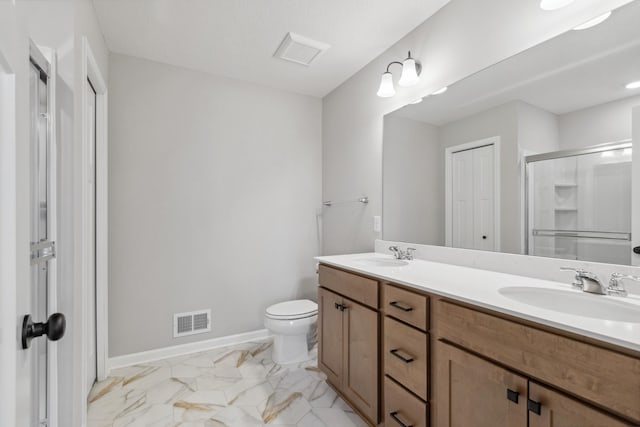 bathroom with vanity, toilet, and a shower with shower door