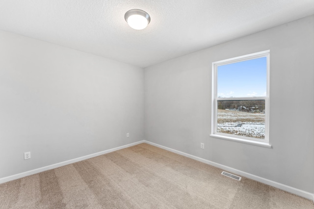 spare room featuring carpet flooring and a textured ceiling