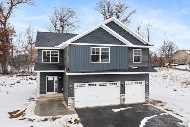 craftsman-style home with a shingled roof, stone siding, driveway, and an attached garage