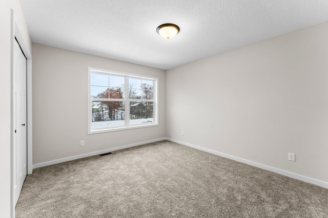 unfurnished bedroom with carpet, a textured ceiling, and a closet