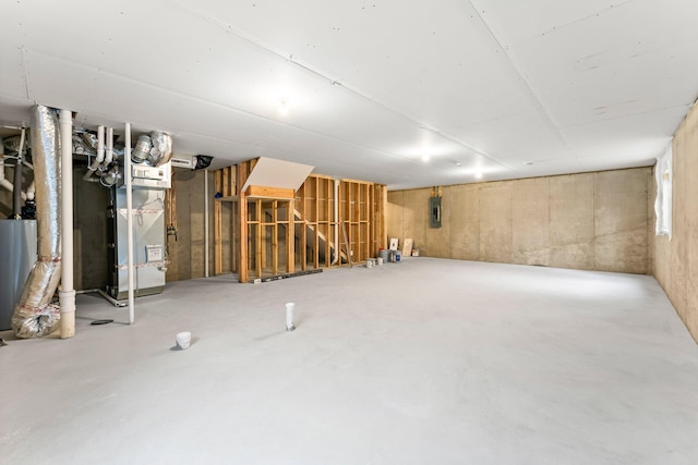 unfinished basement featuring electric panel and heating unit