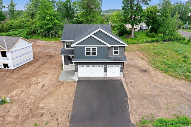 19498 Carson Ct NW, Elk River, MN 55330 - view of front of property with asphalt driveway, a garage, and stone siding