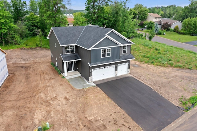 19498 Carson Ct NW, Elk River, MN 55330 - view of front of home with asphalt driveway, a garage, and view of wooded area