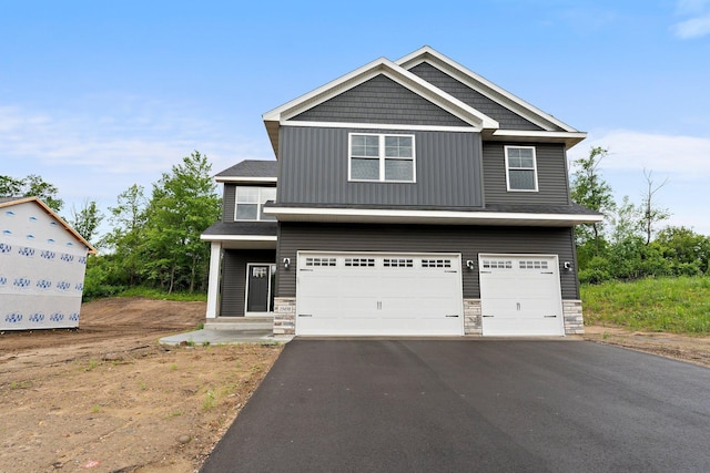 19498 Carson Ct NW, Elk River, MN 55330 - craftsman inspired home with driveway, an attached garage, and stone siding