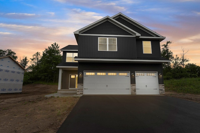 19498 Carson Ct NW, Elk River, MN 55330 - craftsman-style house with asphalt driveway, stone siding, and a garage