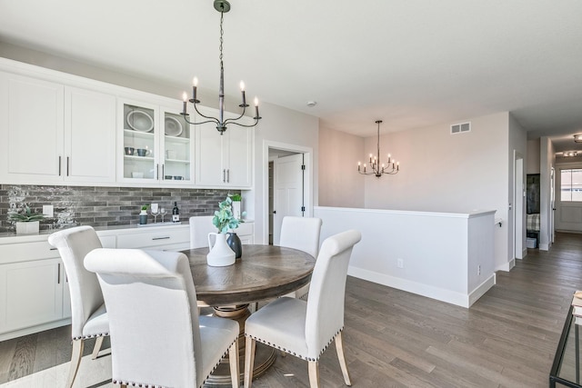 dining space featuring wood-type flooring and a notable chandelier