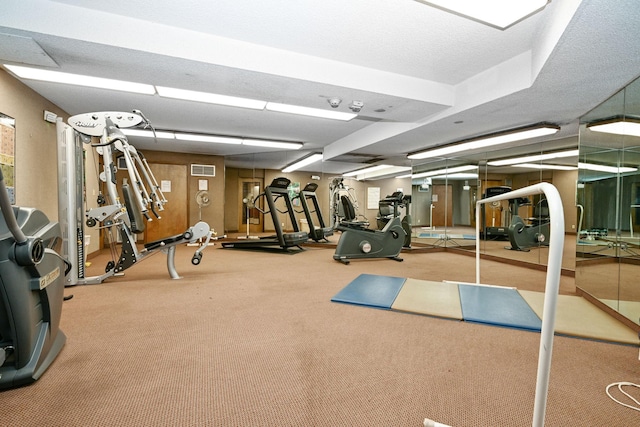 workout area with a textured ceiling and carpet flooring