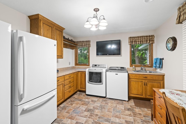 13640 Hagedorn Rd NW, Brandon, MN 56315 - laundry area featuring a sink, an inviting chandelier, independent washer and dryer, stone finish flooring, and laundry area