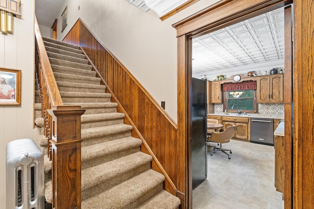 13640 Hagedorn Rd NW, Brandon, MN 56315 - staircase with built in desk, an ornate ceiling, wood walls, and wainscoting