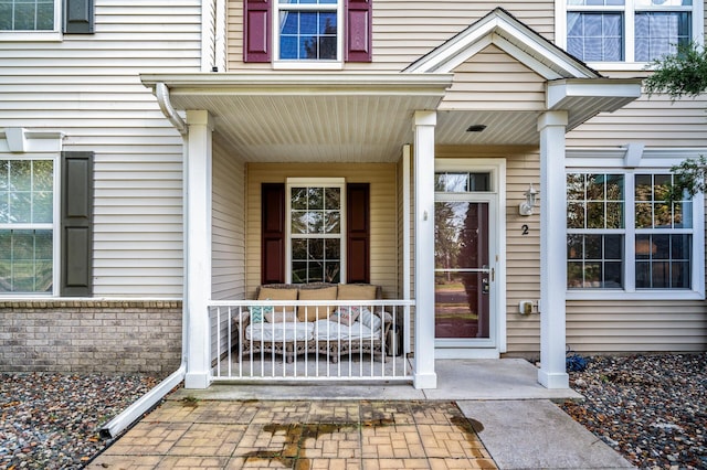 view of exterior entry featuring covered porch