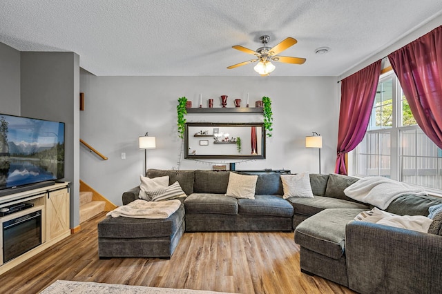 living room with ceiling fan, hardwood / wood-style floors, and a textured ceiling