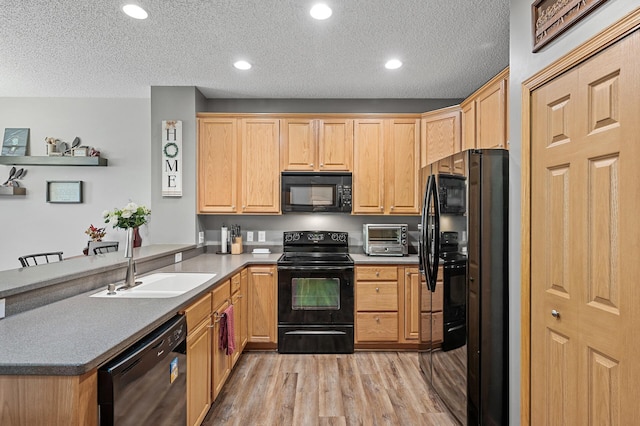 kitchen with black appliances, light hardwood / wood-style flooring, a textured ceiling, and sink