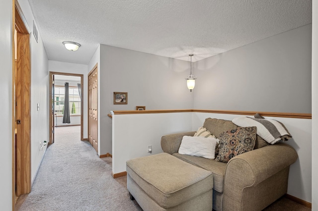 living area with a textured ceiling and light carpet