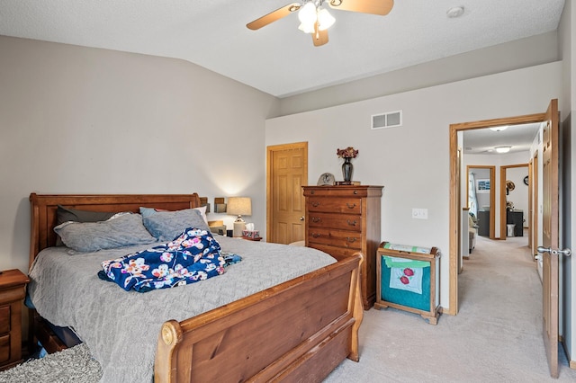 carpeted bedroom featuring lofted ceiling, a textured ceiling, and ceiling fan