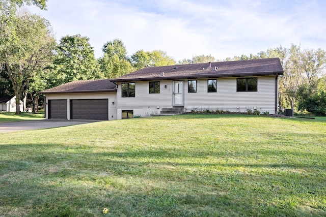 view of front of property with central AC, a front yard, and a garage