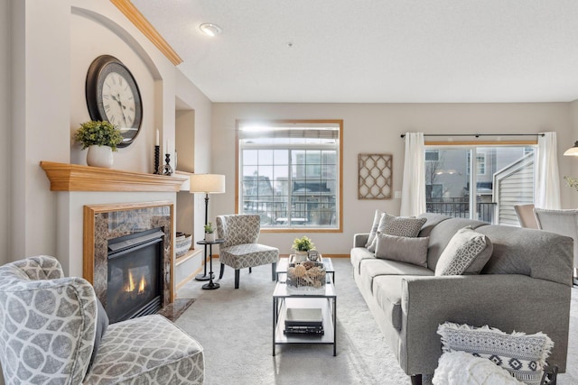 living room with plenty of natural light, a textured ceiling, a premium fireplace, and carpet flooring