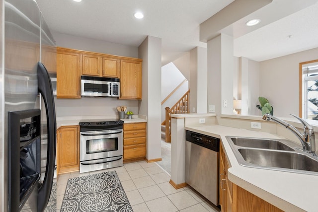 kitchen featuring sink, light tile patterned floors, and stainless steel appliances