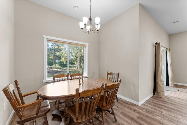 dining space with light wood-type flooring and a chandelier