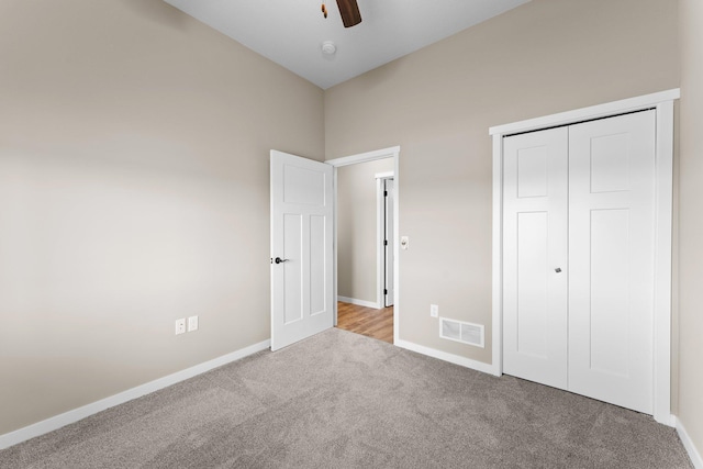 unfurnished bedroom with a closet, ceiling fan, and light colored carpet