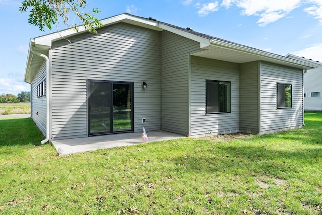 back of property featuring a patio area and a lawn