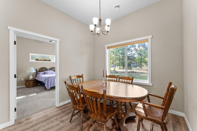 dining space with a notable chandelier and light hardwood / wood-style floors