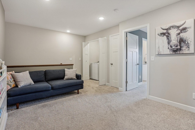 living room with light carpet and washer / clothes dryer