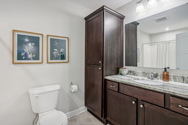 bathroom featuring a shower with shower curtain, vanity, and toilet