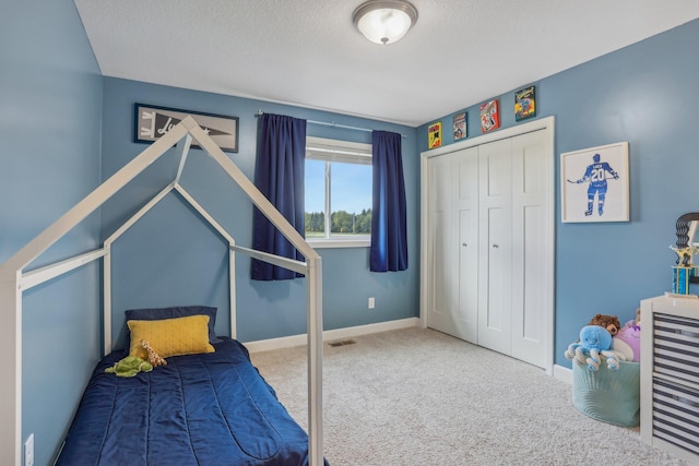 bedroom featuring carpet, a closet, and a textured ceiling