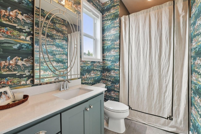 bathroom featuring vanity, toilet, and wallpapered walls