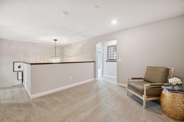 sitting room featuring baseboards and light colored carpet