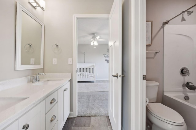 bathroom with double vanity, toilet, a sink, and shower / bathing tub combination