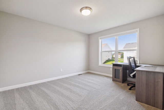 office space with baseboards and light colored carpet