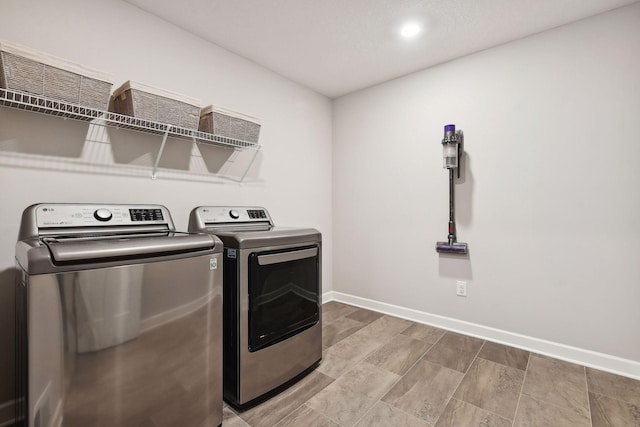 washroom with laundry area, baseboards, and washing machine and clothes dryer