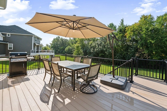 wooden deck featuring a yard, outdoor dining space, and area for grilling