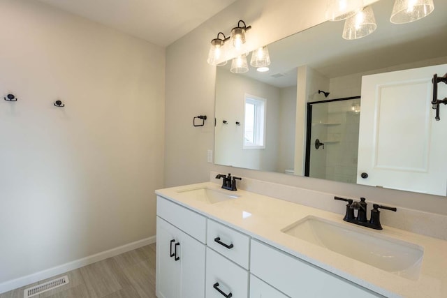 bathroom featuring wood-type flooring, vanity, and a shower with door