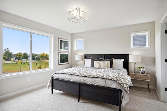 bedroom featuring a notable chandelier and light colored carpet