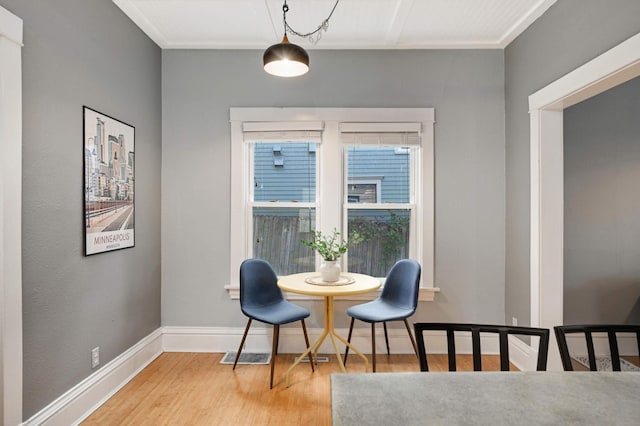 dining room featuring hardwood / wood-style flooring and crown molding