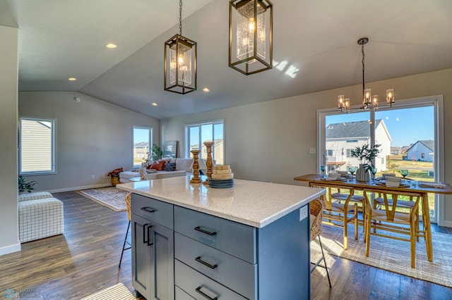 kitchen with lofted ceiling, pendant lighting, dark hardwood / wood-style floors, and a breakfast bar