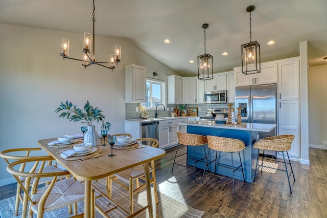 kitchen featuring white cabinets, a center island, vaulted ceiling, stainless steel appliances, and dark hardwood / wood-style floors