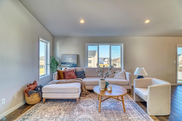 living room with dark wood-type flooring and plenty of natural light