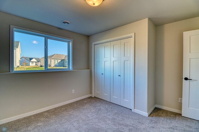 unfurnished bedroom featuring a closet and light carpet