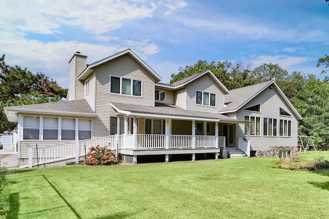 rear view of house featuring a porch and a yard