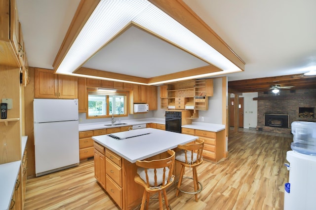 kitchen featuring a brick fireplace, open shelves, white appliances, a raised ceiling, and a sink