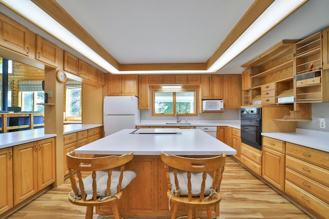 kitchen featuring a sink, open shelves, white appliances, light wood finished floors, and light countertops