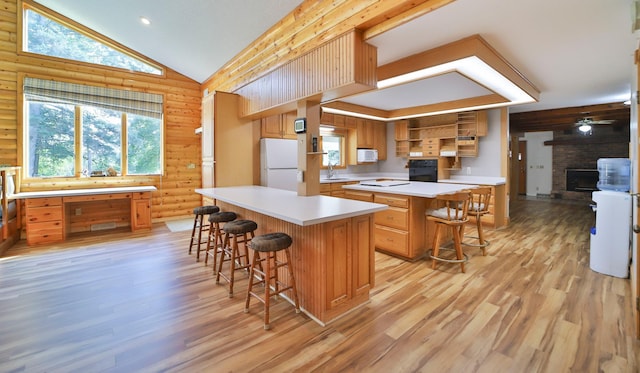 kitchen featuring a center island, a kitchen bar, light countertops, white appliances, and open shelves