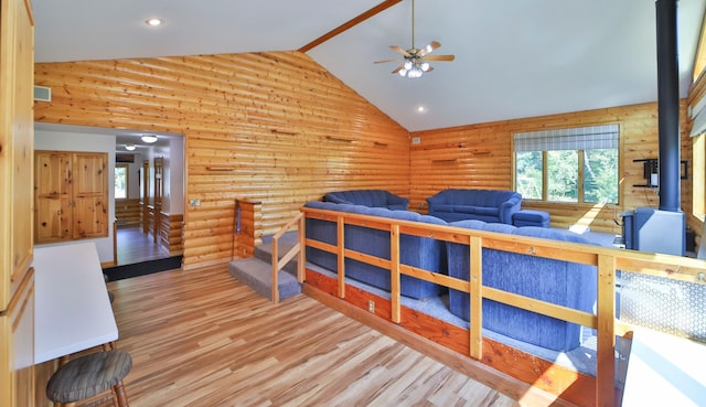 bedroom featuring rustic walls, recessed lighting, wood finished floors, and high vaulted ceiling