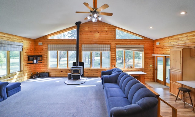 living room featuring recessed lighting, a healthy amount of sunlight, a wood stove, and a ceiling fan